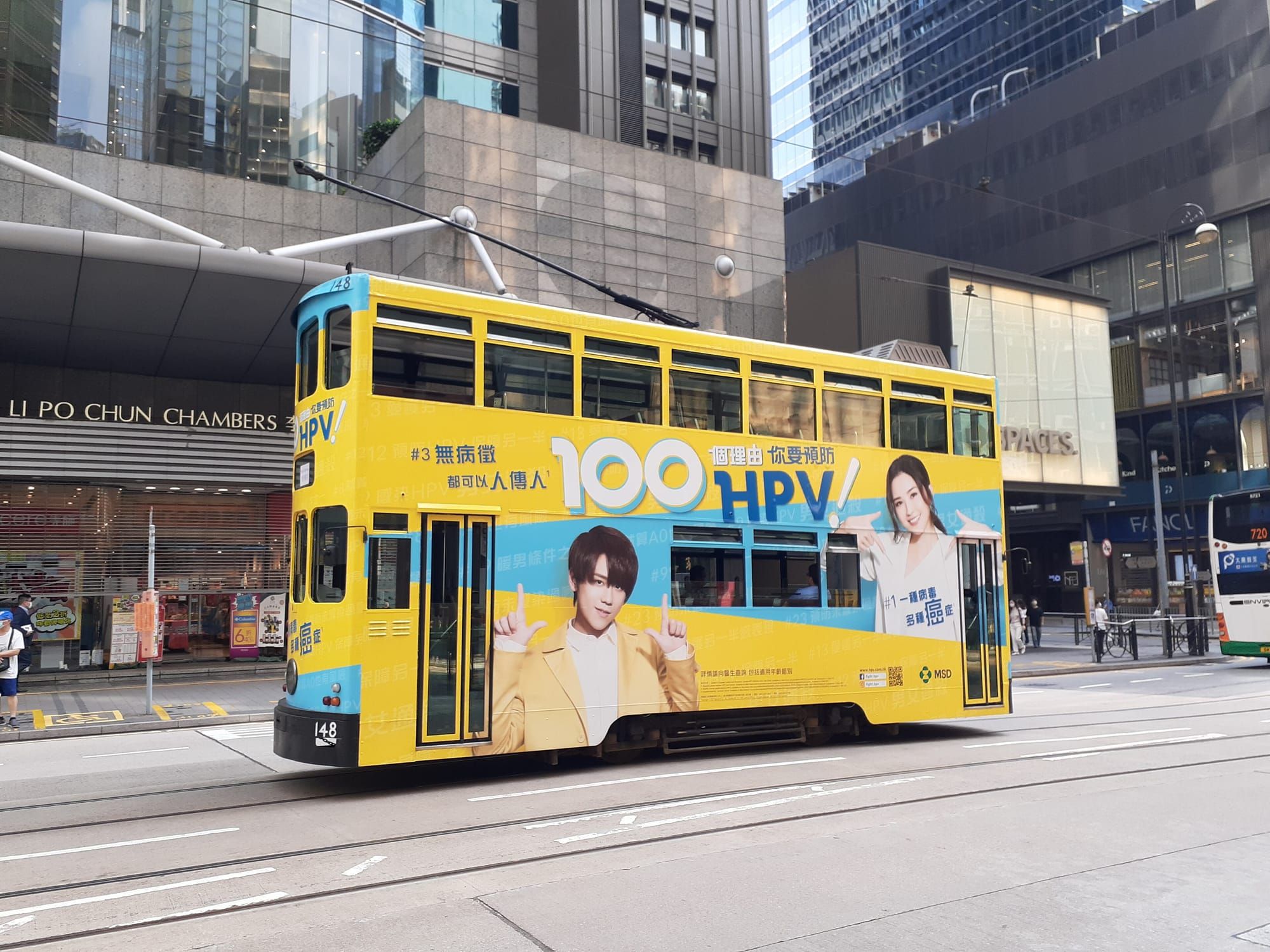 A yellow double-decker tram on Des Voeux Road Central